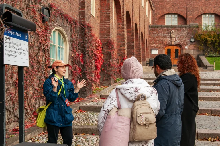 Local Xpert guiding guests past red-brick buildings on the Stockholm Innovation Tour