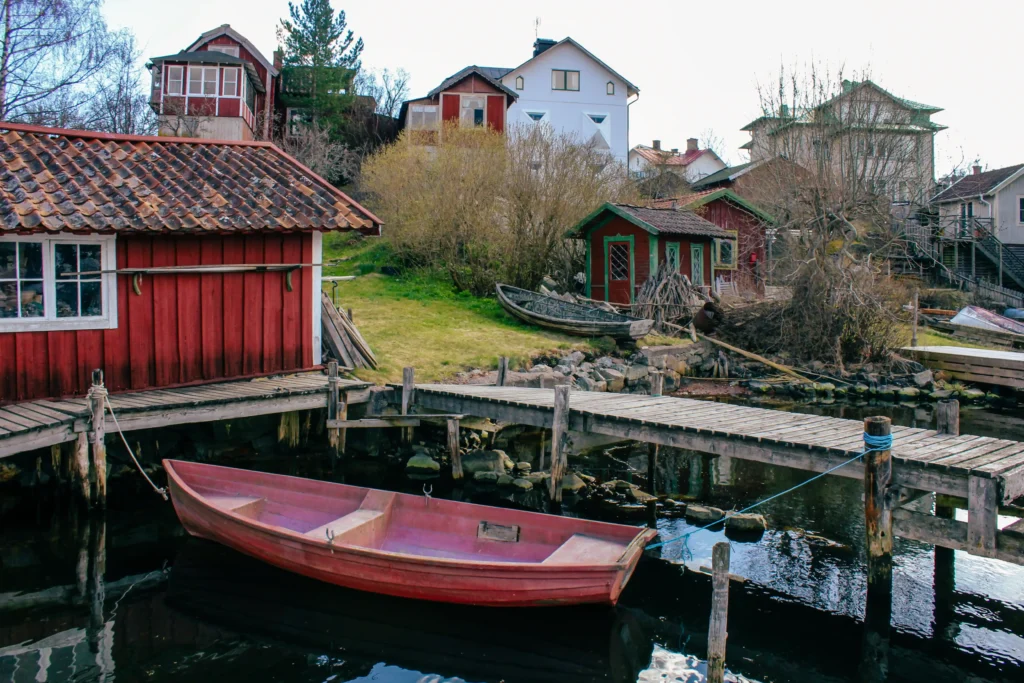 Red wooden boathouse and rowing boat in Vaxholm