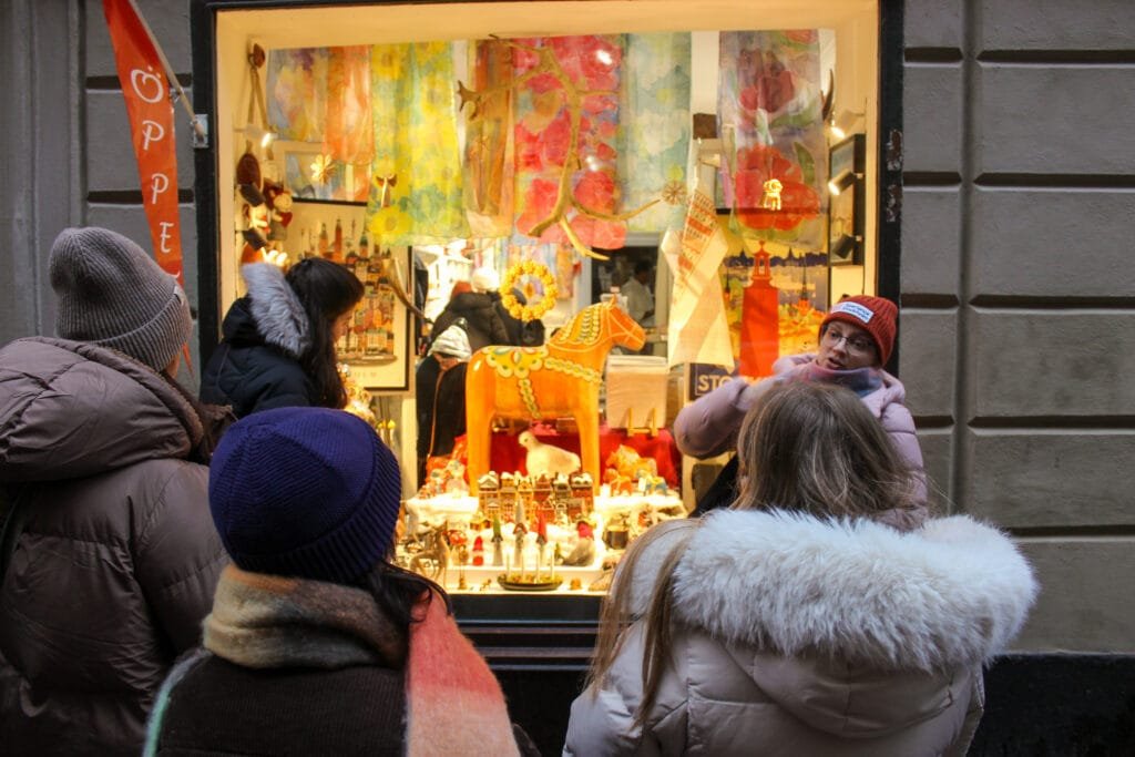Guests at a colourful shop window on a Stockholm winter tour