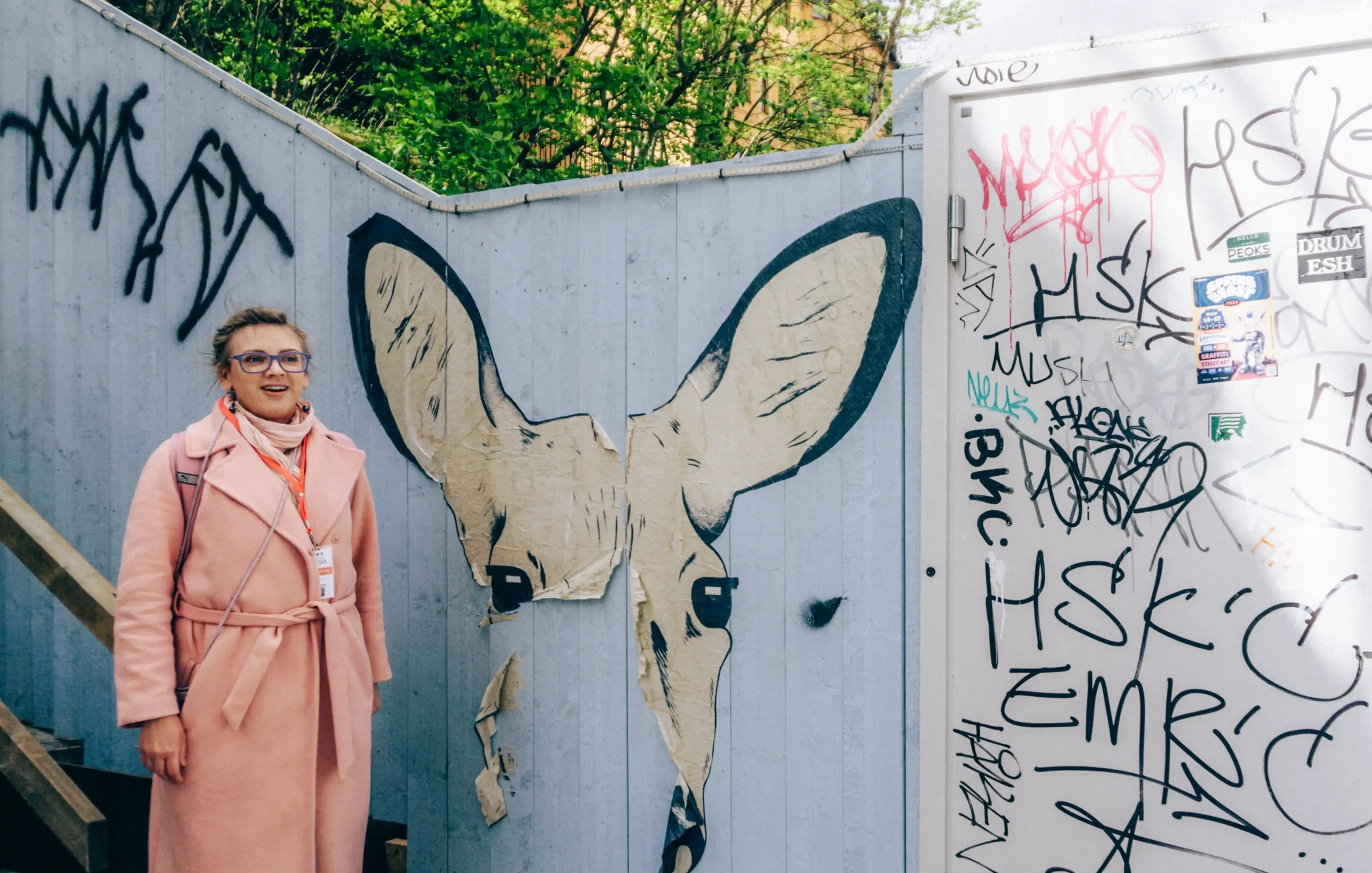 Olesia beside graffiti art on the Stockholm Urban Art Tour
