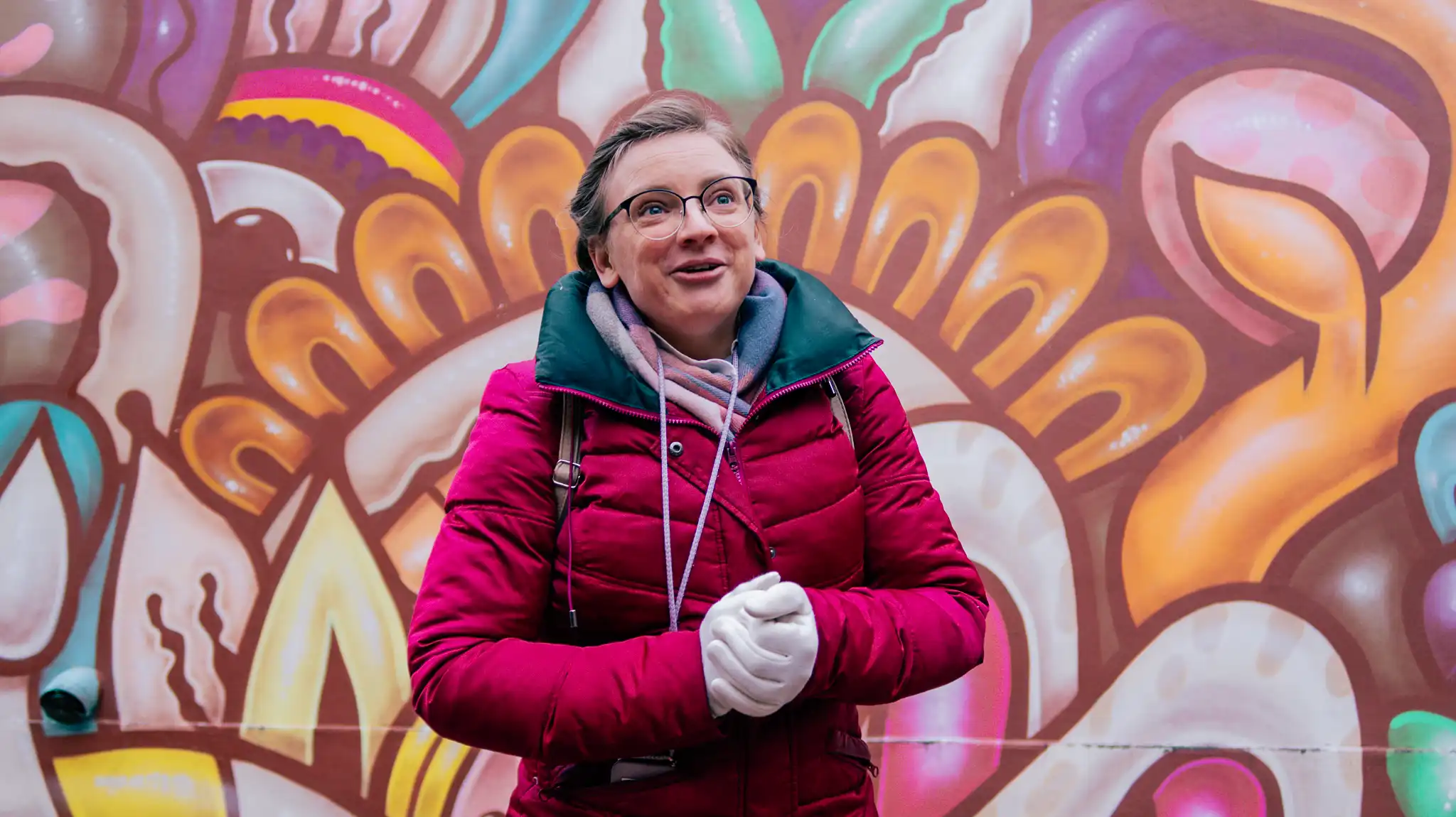 Olesia in front of a colourful mural on the Stockholm Urban Art Tour