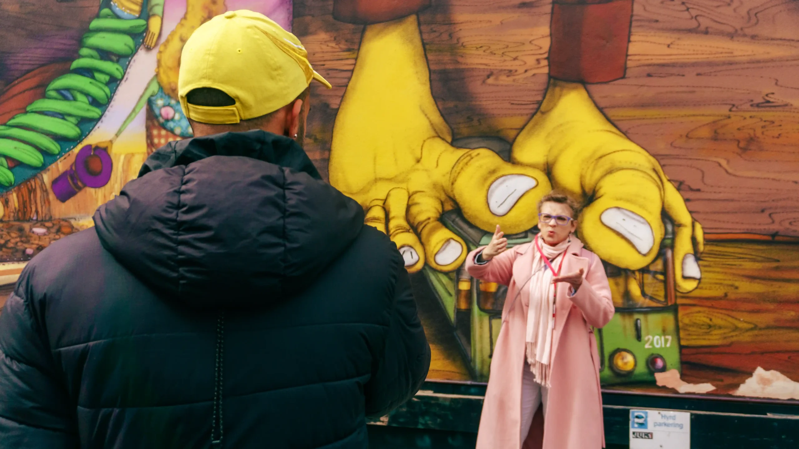 Guest viewing an Os Gemeos mural on the Stockholm Urban Art Tour