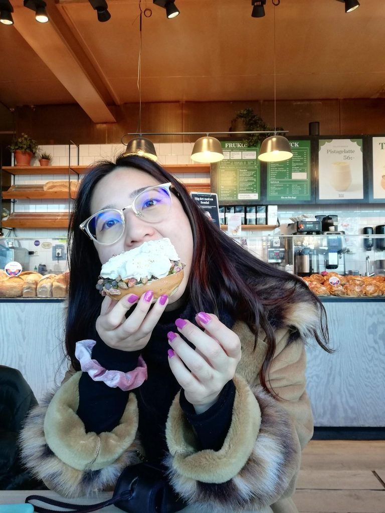 Amelie eating a pistachio semla.